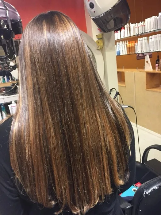 Long straight highlighted hair blow-dried at Creative Cuts Plus